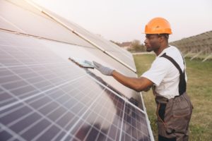 African,American,Dedicated,Technician,Cleans,Large,Solar,Panels,In,An